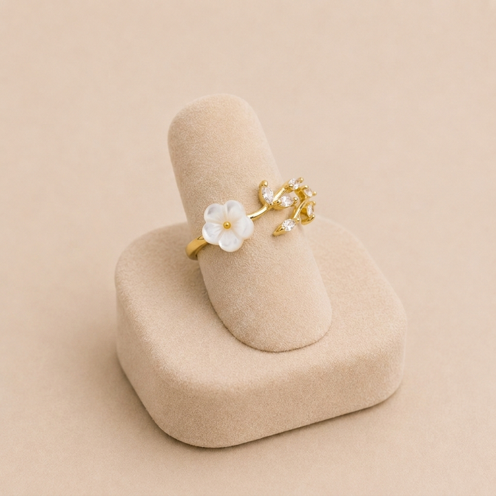 Miriam – Gold ring with white floral decoration.