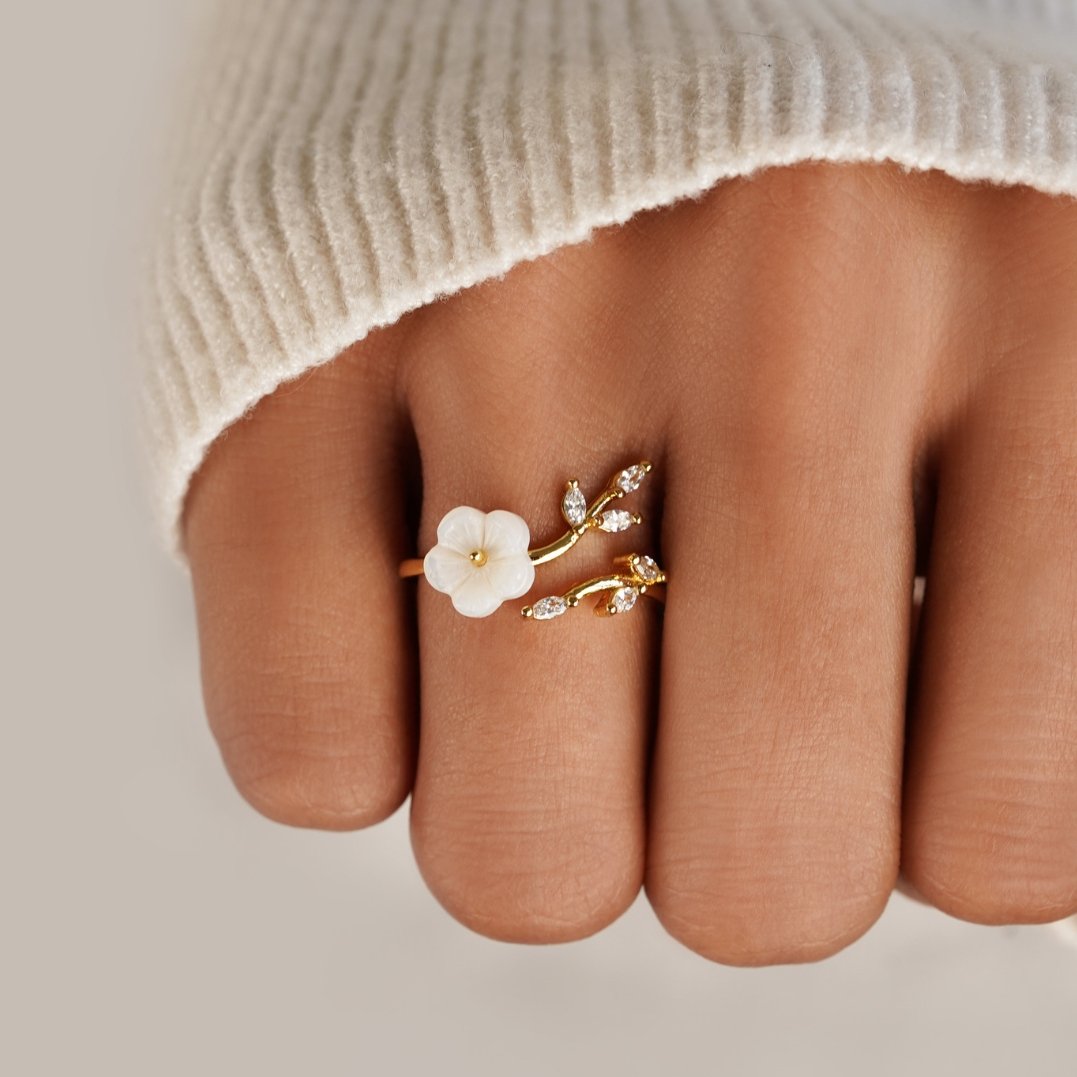 Miriam – Gold ring with white floral decoration.