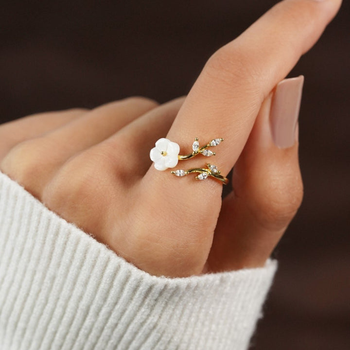 Miriam – Gold ring with white floral decoration.