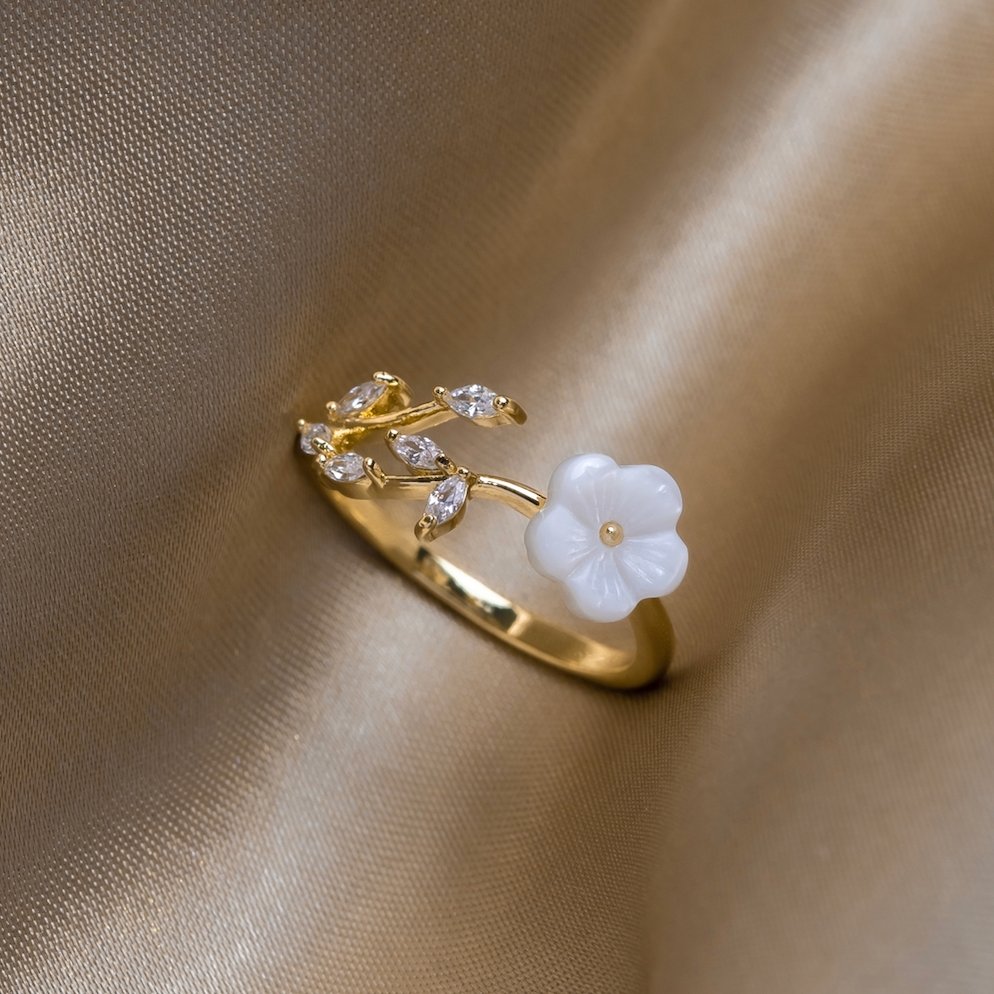Miriam – Gold ring with white floral decoration.