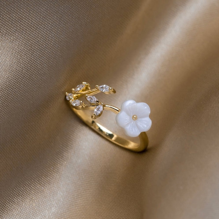 Miriam – Gold ring with white floral decoration.