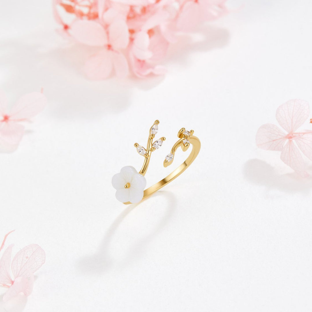 Miriam – Gold ring with white floral decoration.