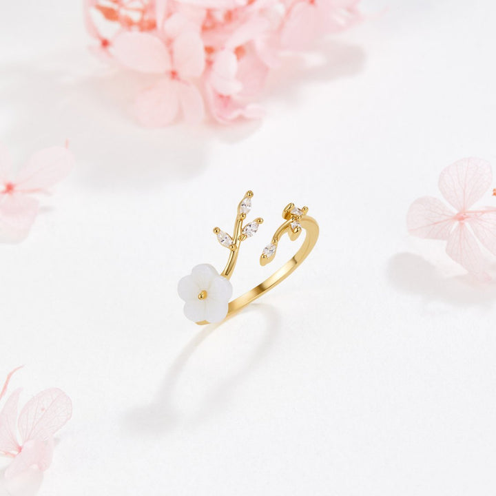 Miriam – Gold ring with white floral decoration.